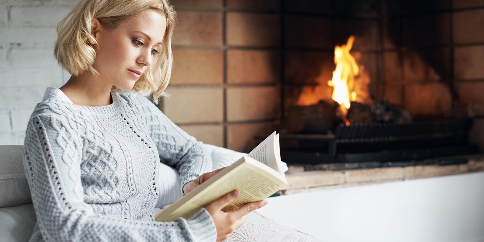 woman-sitting-by-fireplace-reading-3x2