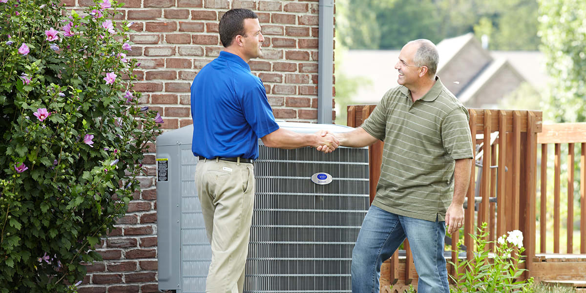 carrier-technician-explaining-to-a-customer-what-a-heat-pump-is