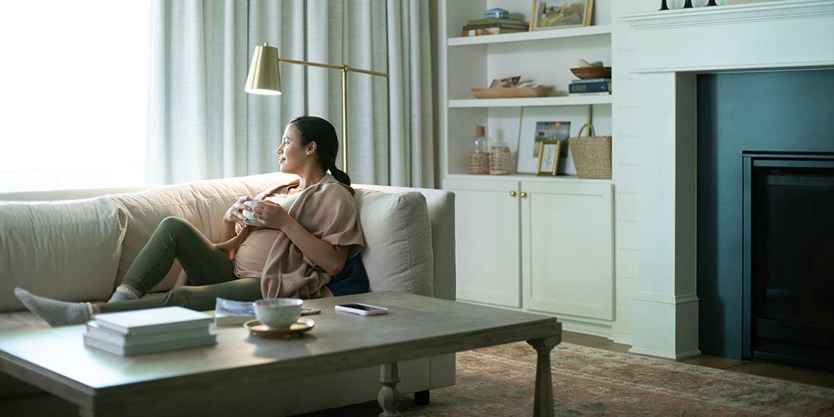 woman-sitting-on-a-couch-wondering-what-size-air-conditioner-do-I-need