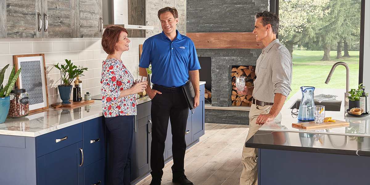 a-carrier-dealer-speaking-to-a-couple-in-their-kitchen-about-hvac-replacement