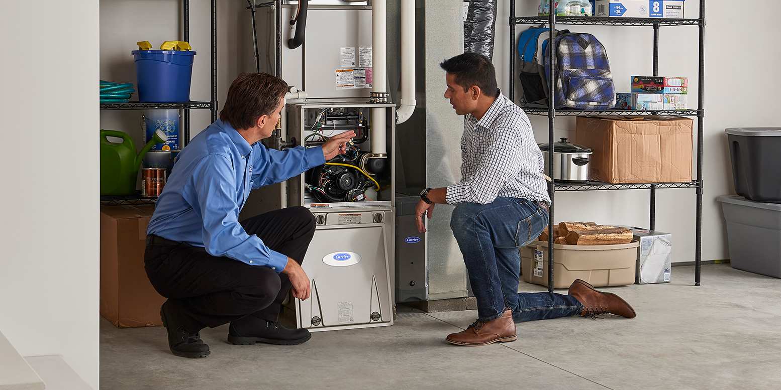 a-carrier-dealer-talks-to-a-homeowner-after-performing-furnace-installation