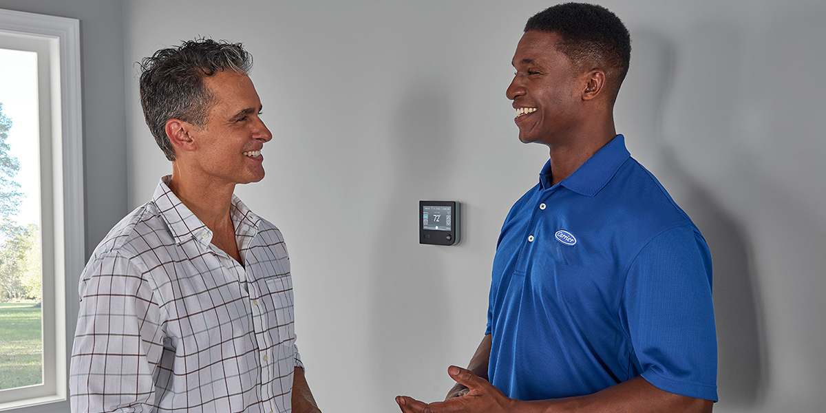 a-carrier-dealer-talks-to-a-homeowner-about-heat-pump-tax-credits