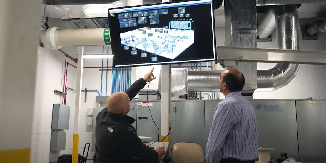 men looking at screen with hvac graphics and control systems