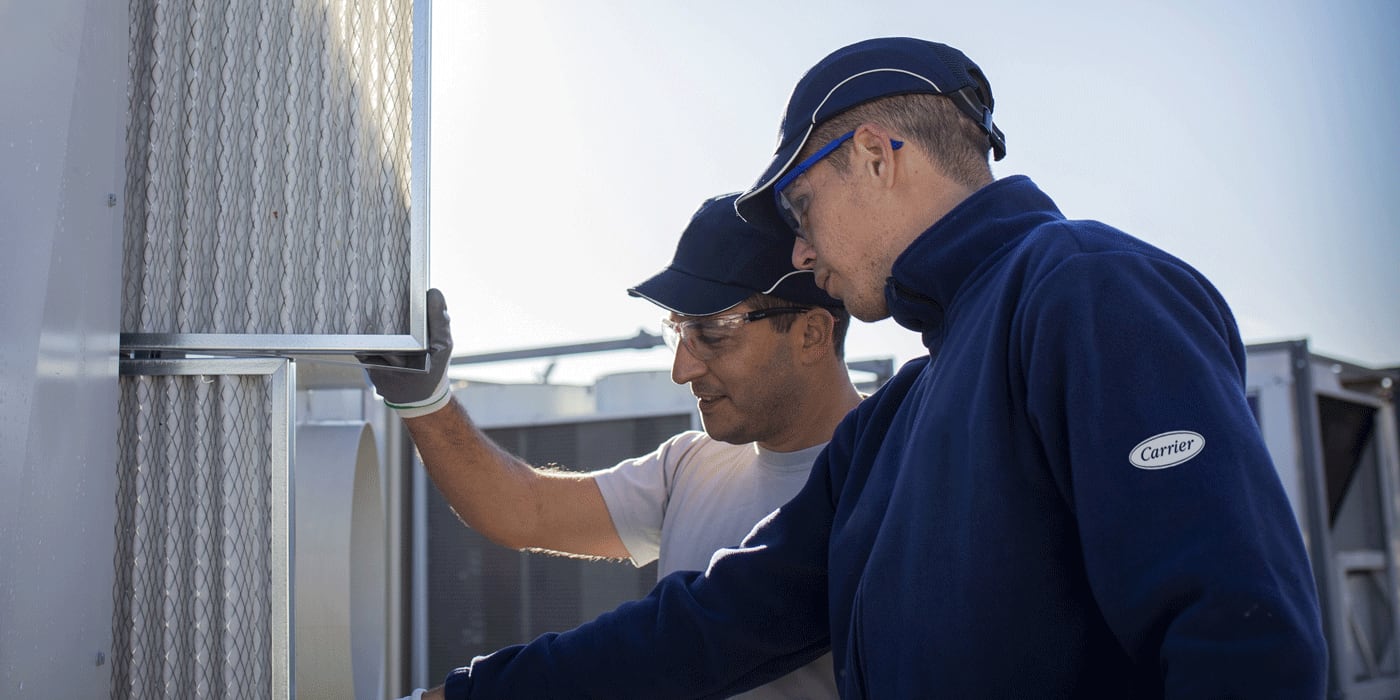 Técnico utilizando repuestos para aire acondicionado, tratamiento de aire, calefacción y refrigeración originales durante una reparación in situ