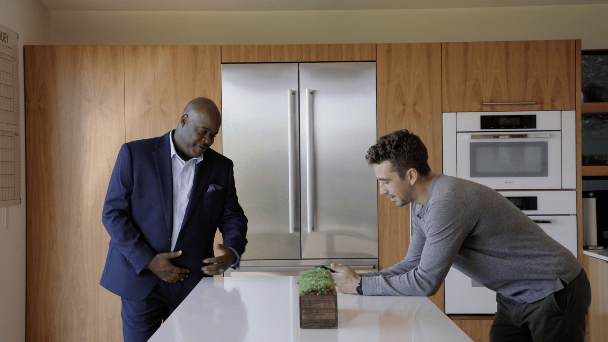 Two men in a kitchen having a discussion