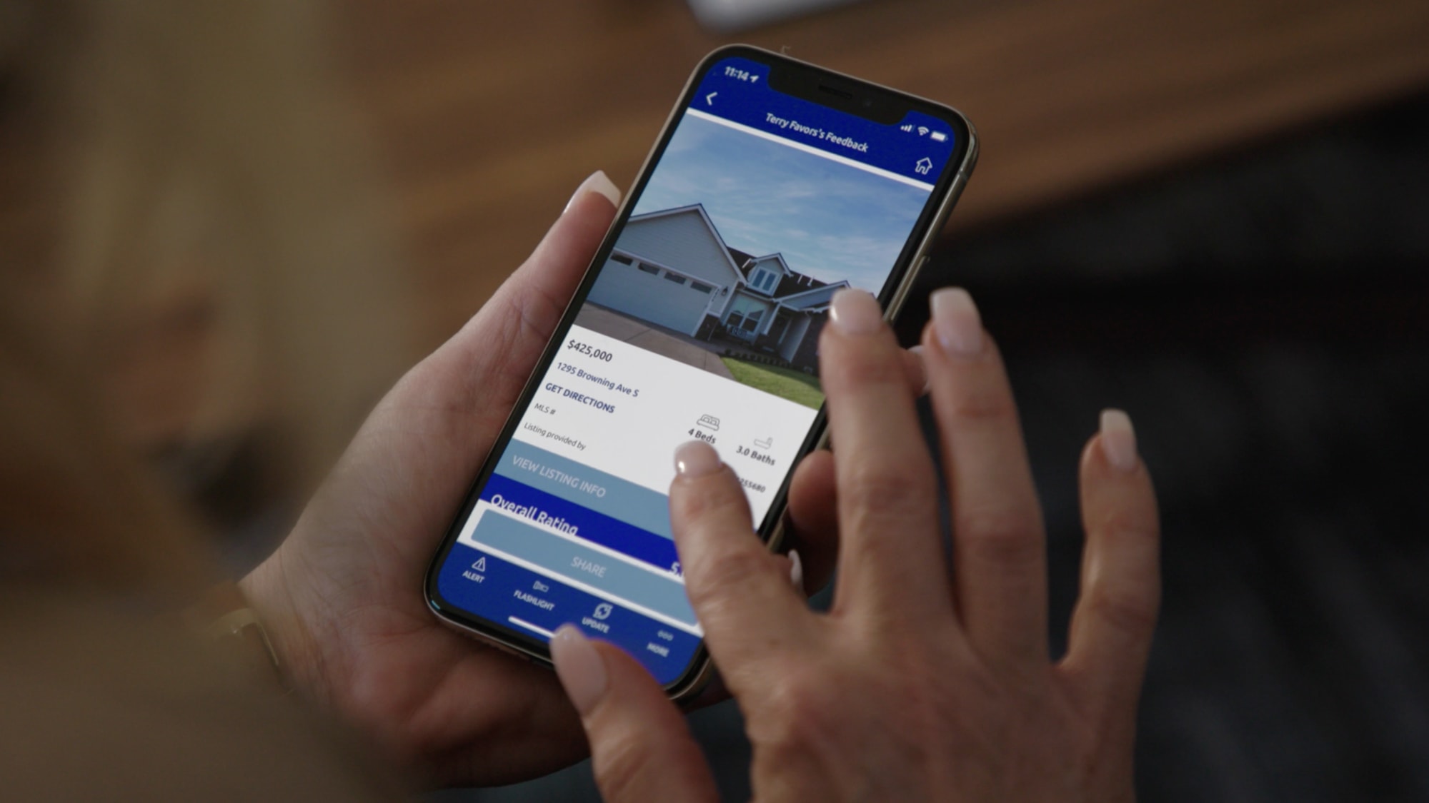 Real estate agent using Supra eKEY pro app to see home photo and price details.