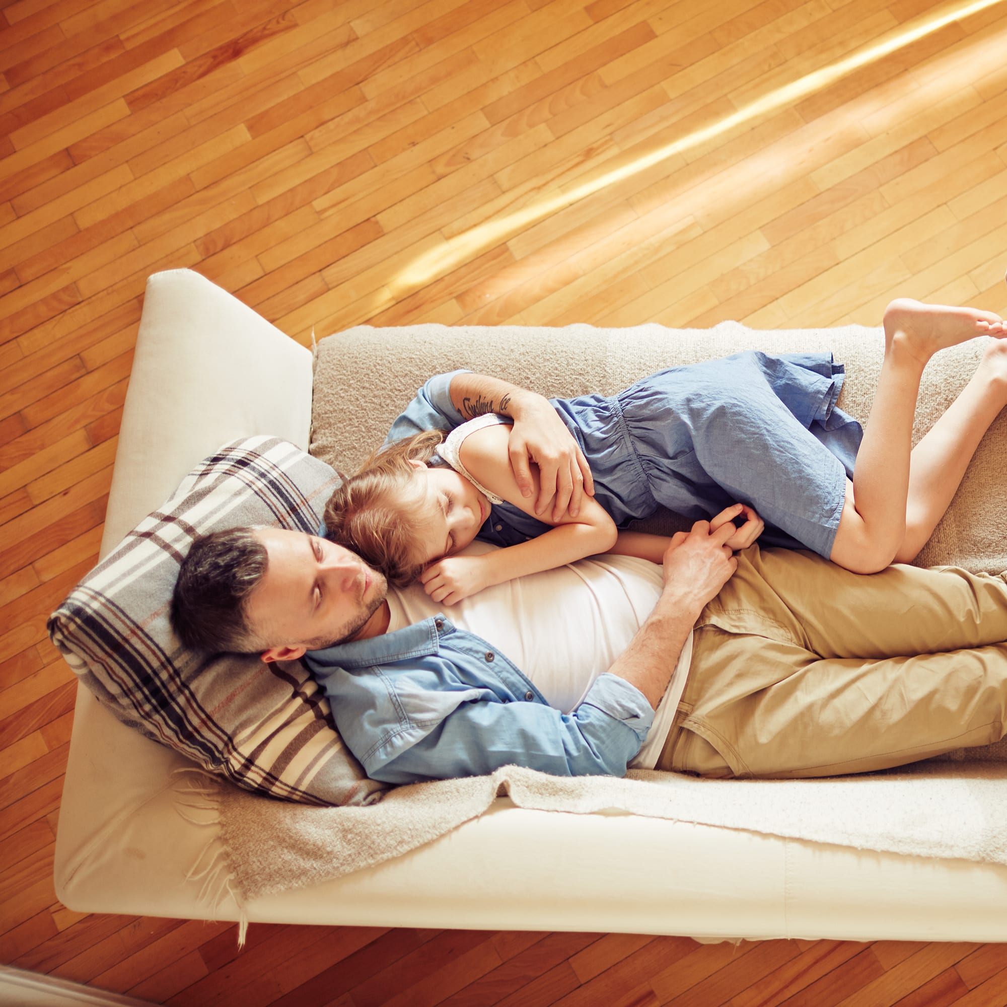 family-relaxing-couch-mother-father-daughter_sq