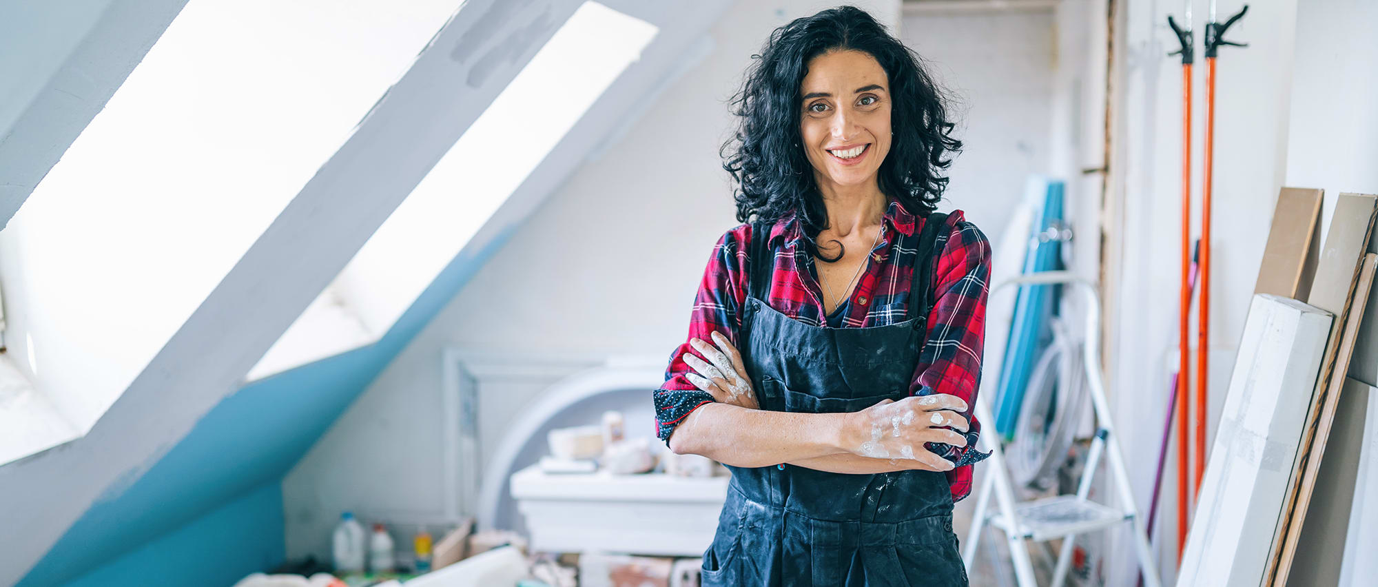 woman-in-loft-with-plaid-shirt-maintaining-home woman stands in loft after cleaning fan coil unit