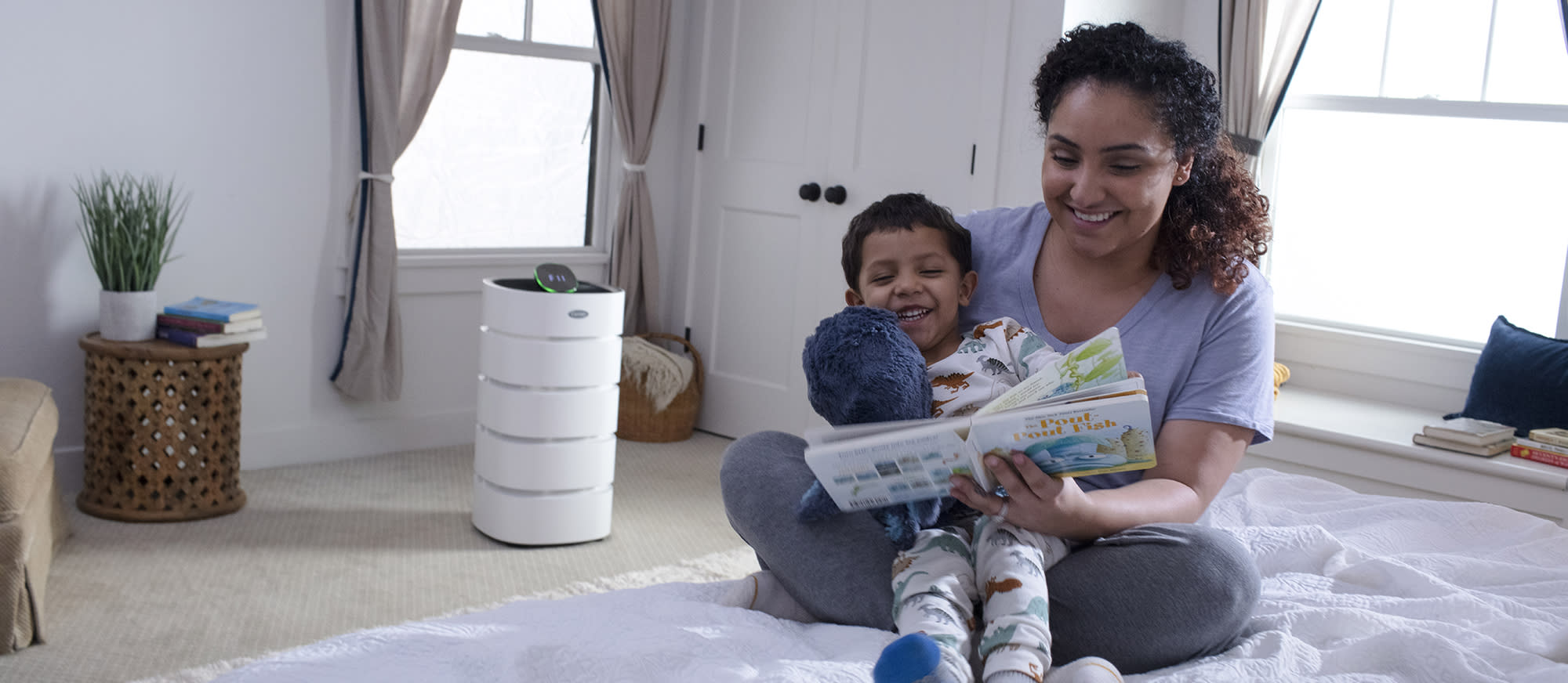 benefits-of-air-purifiers a woman reads book to son about benefits of air purifiers