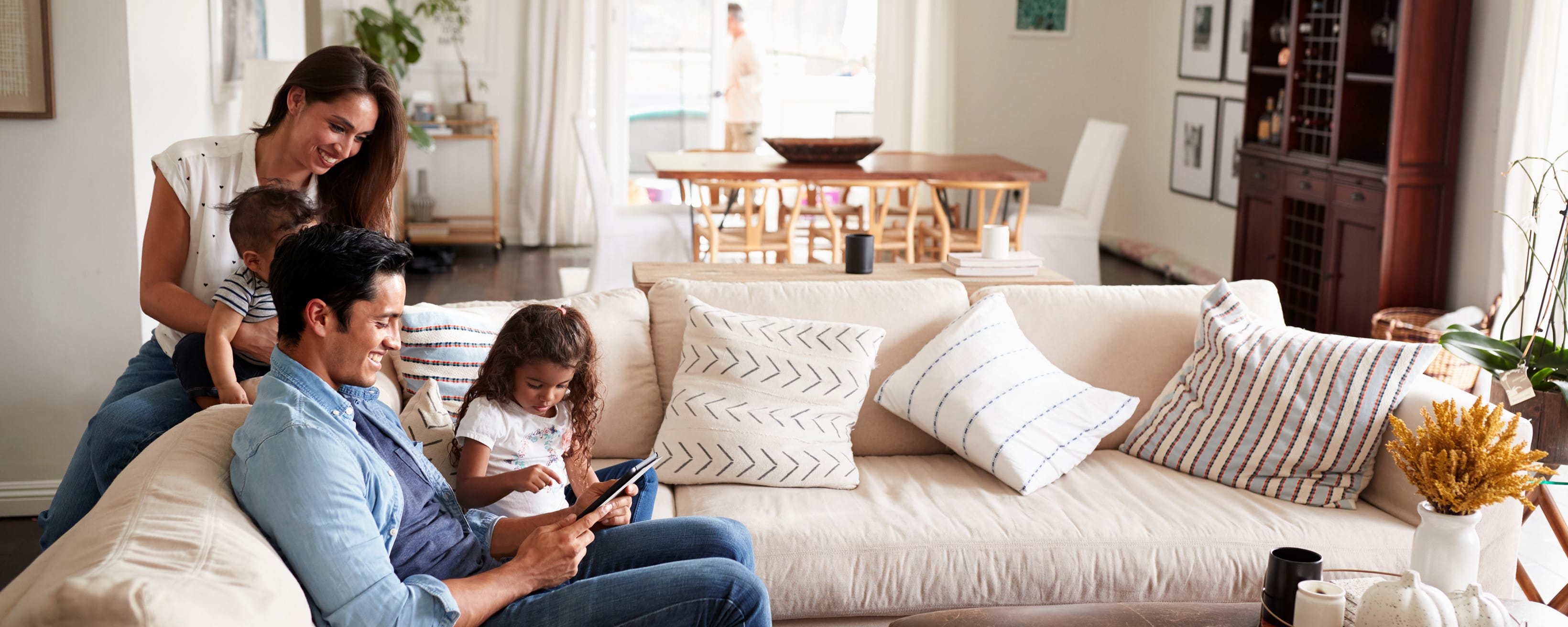 young-hispanic-family-sitting-on-sofa-reading-a-book-5x1 young-hispanic-family-sitting-on-sofa-reading-a-book-5x1