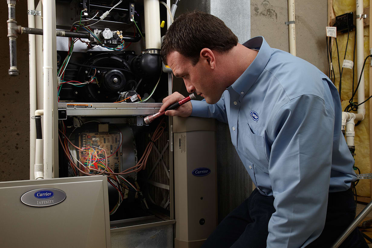 cost of furnace repair a carrier dealer with a flashlight exploring the cost of furnace repair