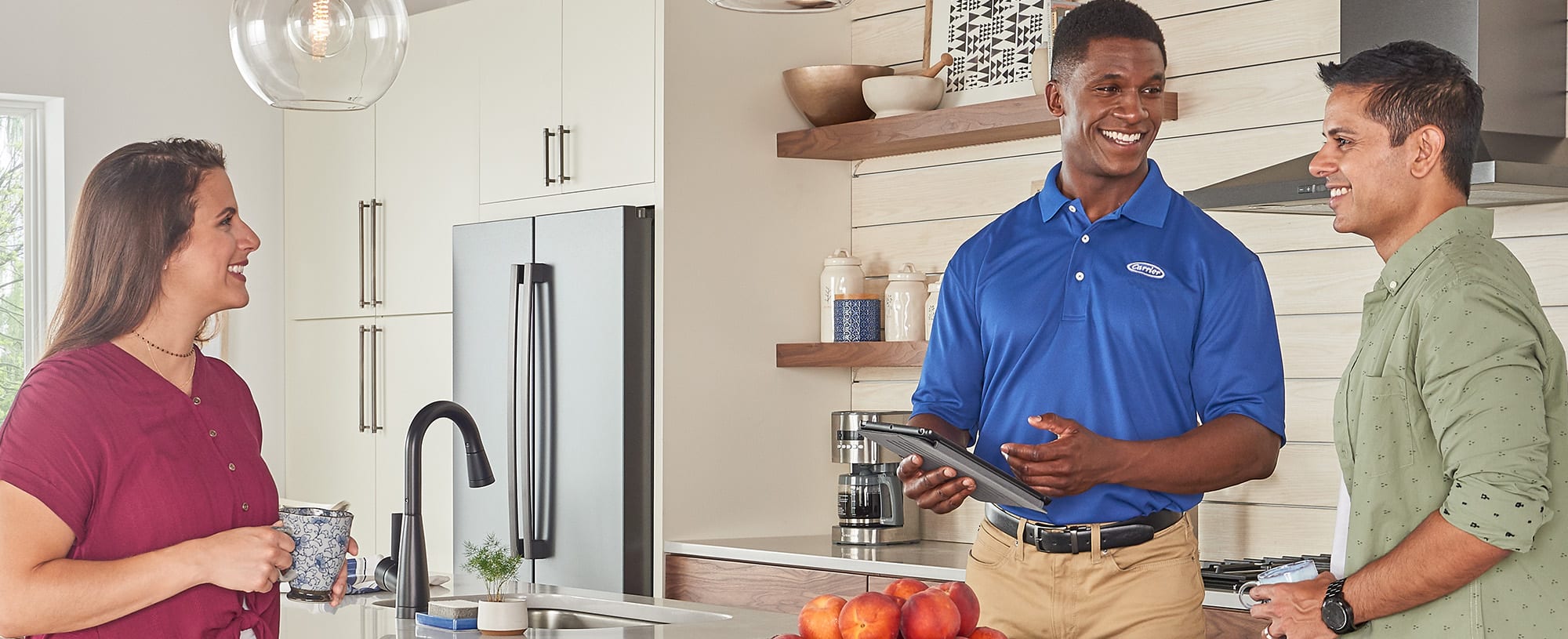 Carrier dealer speaking to a couple in their kitchen about gas furnace replacement cost