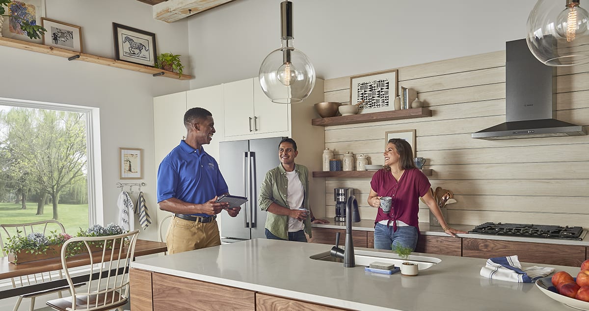 a carrier dealer talks about benefits of a humidifier with a man and woman a carrier dealer talks about benefits of a humidifier with a man and woman