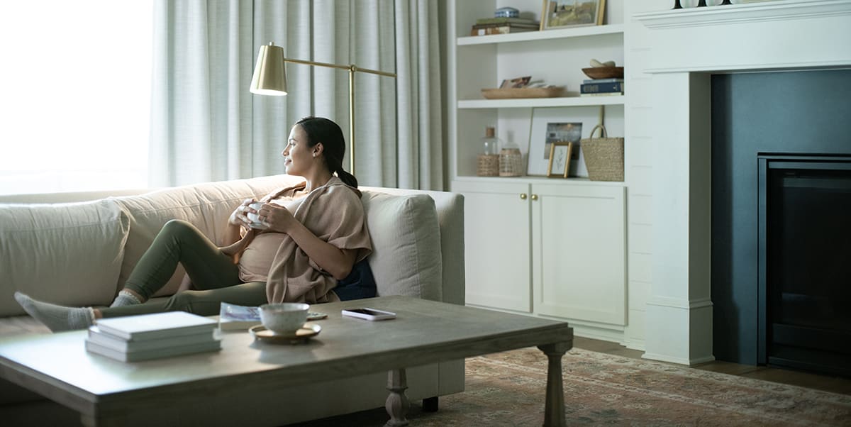 a woman relaxes on the couch in a home with a carrier heat recovery ventilation system installed a woman relaxes on the couch in a home with a carrier heat recovery ventilation system installed