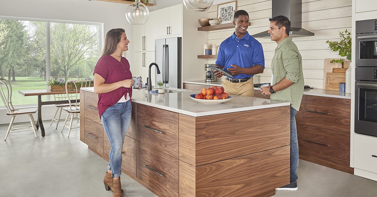 a carrier dealer discusses ground source heat pump cost with a couple a carrier dealer discusses ground source heat pump cost with a couple