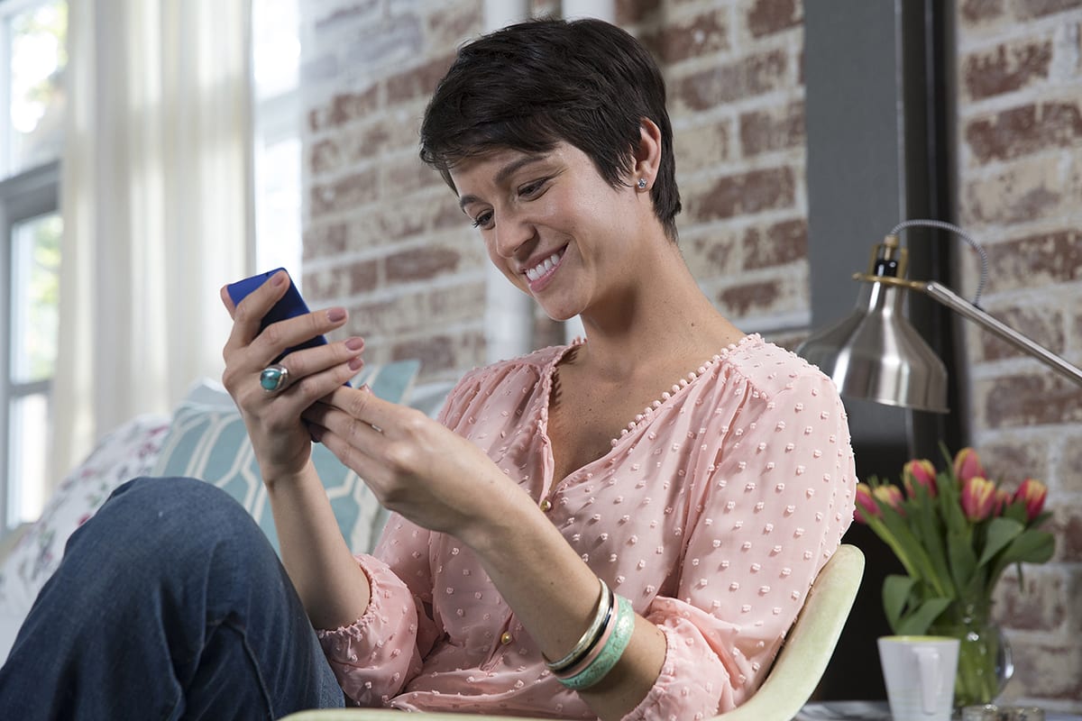 a woman looks for gas furnace repair near me on her phone a woman looks for gas furnace repair near me on her phone