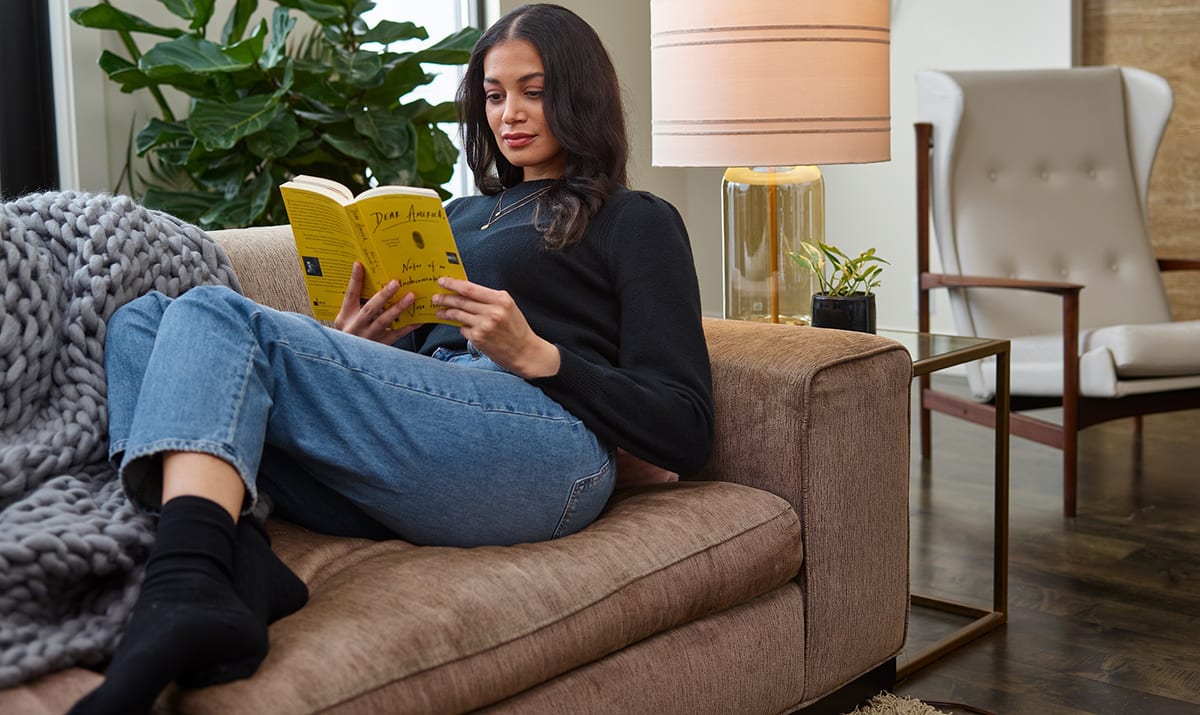 a homeowner reads a book on couch in home with clean air after air duct cleaning a homeowner reads a book on couch in home with clean air after air duct cleaning