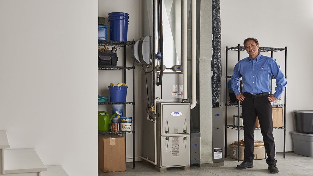 a carrier dealer stands next to an installed down flow furnace a carrier dealer stands next to an installed down flow furnace