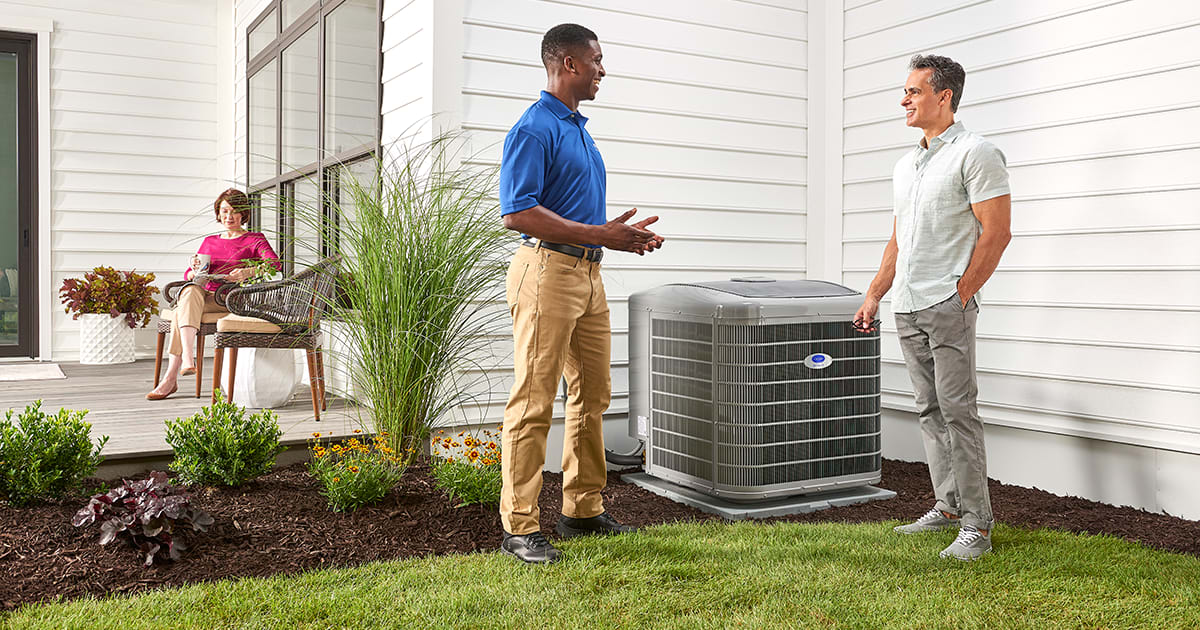 a carrier dealer explains r410a refrigerant to a man outside by ac a carrier dealer explains r410a refrigerant to a man outside by ac