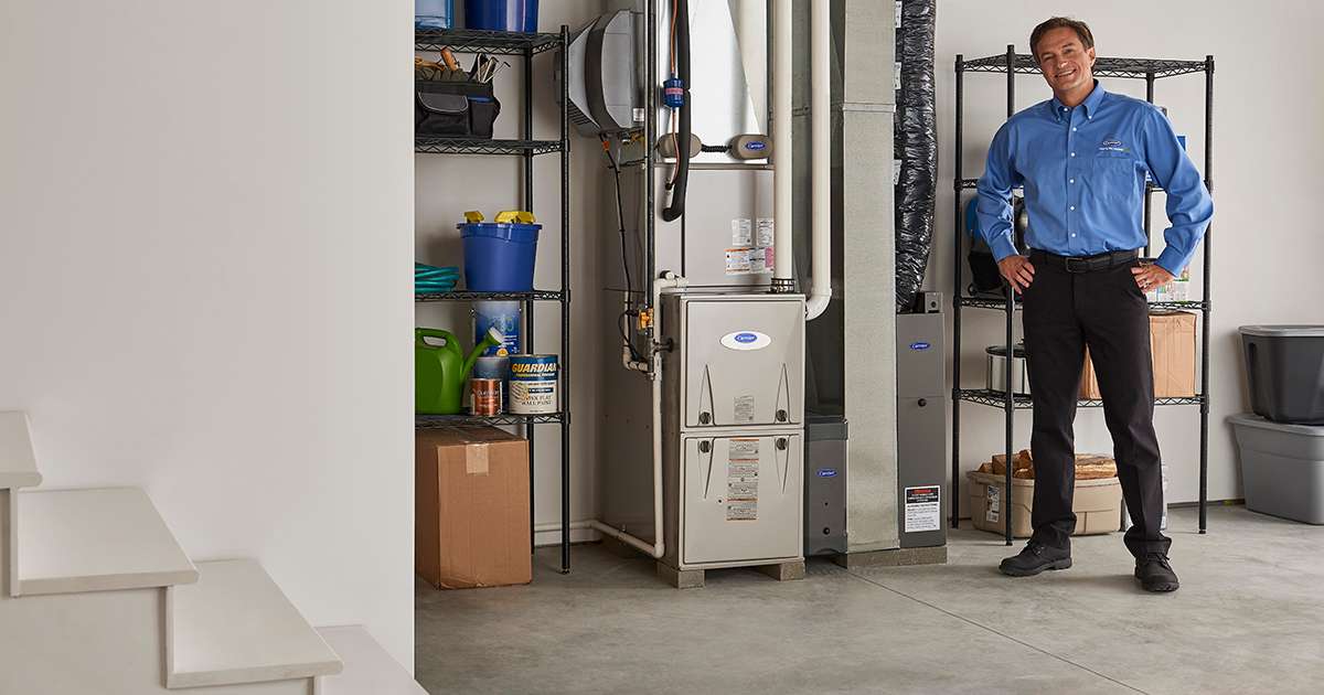 a carrier dealer stands next to natural gas furnace a carrier dealer stands next to natural gas furnace