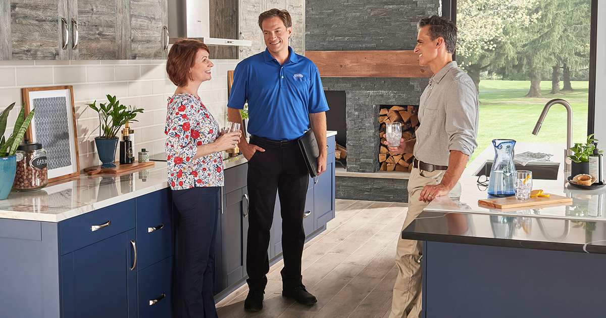 a carrier dealer discusses seer rating vs seer2 with homeowners in kitchen a carrier dealer discusses seer rating vs seer2 with homeowners in kitchen