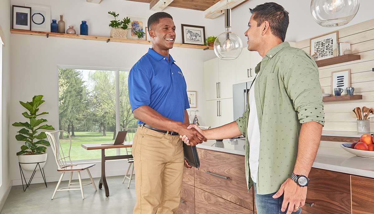 a carrier dealer shakes man's hand after installing hvac ductwork a carrier dealer shakes man's hand after installing hvac ductwork