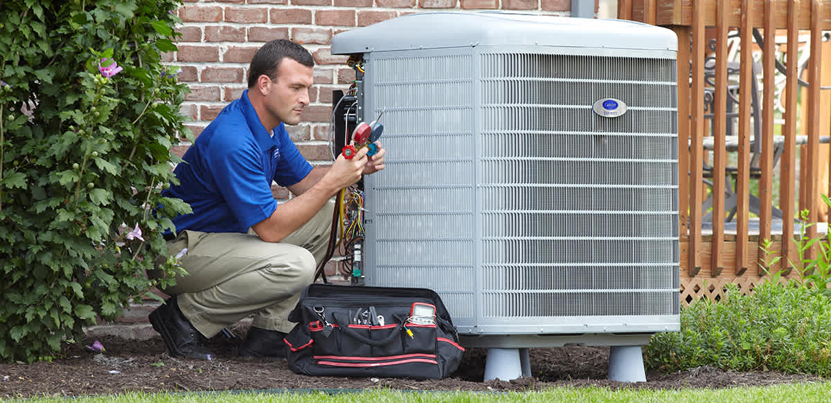 a carrier dealer working on an ac compressor replacement outside of a home a carrier dealer working on an ac compressor replacement outside of a home