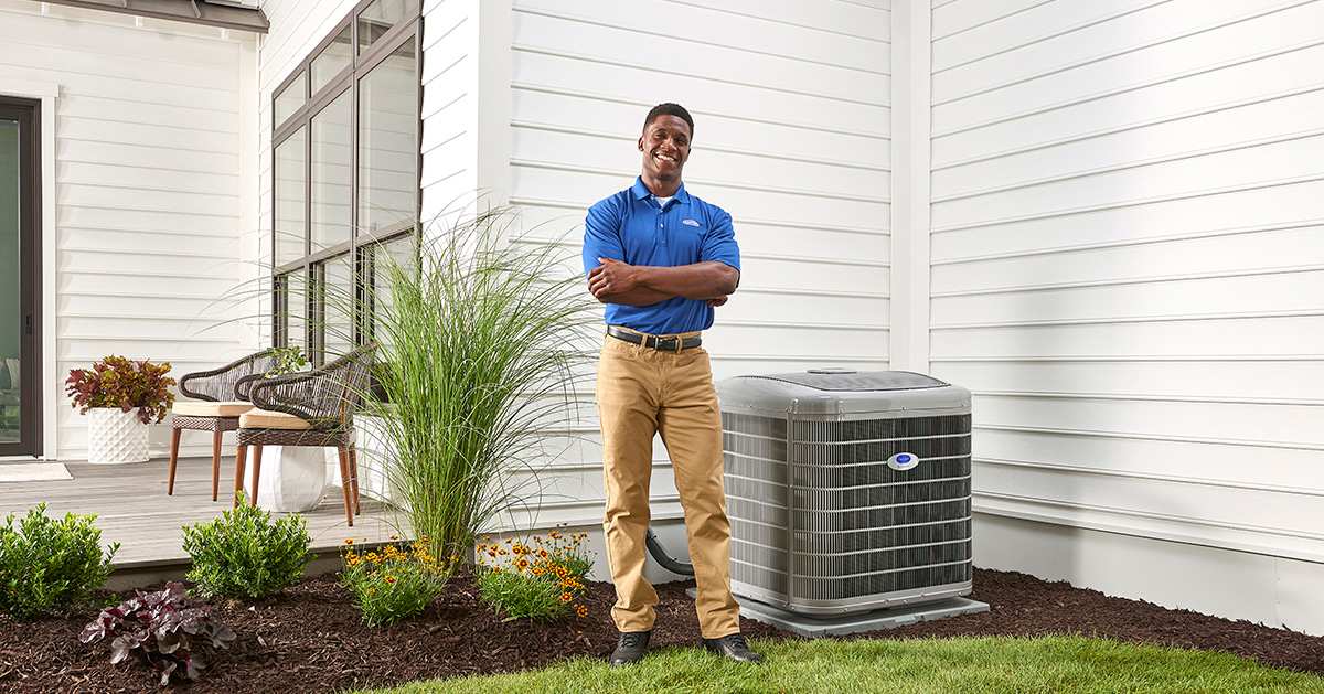 a carrier ac repair near me expert poses next to ac unit a carrier ac repair near me expert poses next to ac unit