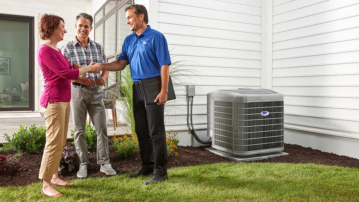 a carrier dealer shakes a woman's hand after installing the best air conditioner for her home