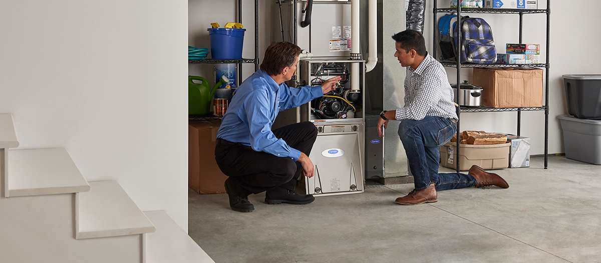 a carrier dealer discusses gas furnace upgrade options with homeowner a carrier dealer discusses gas furnace upgrade options with homeowner