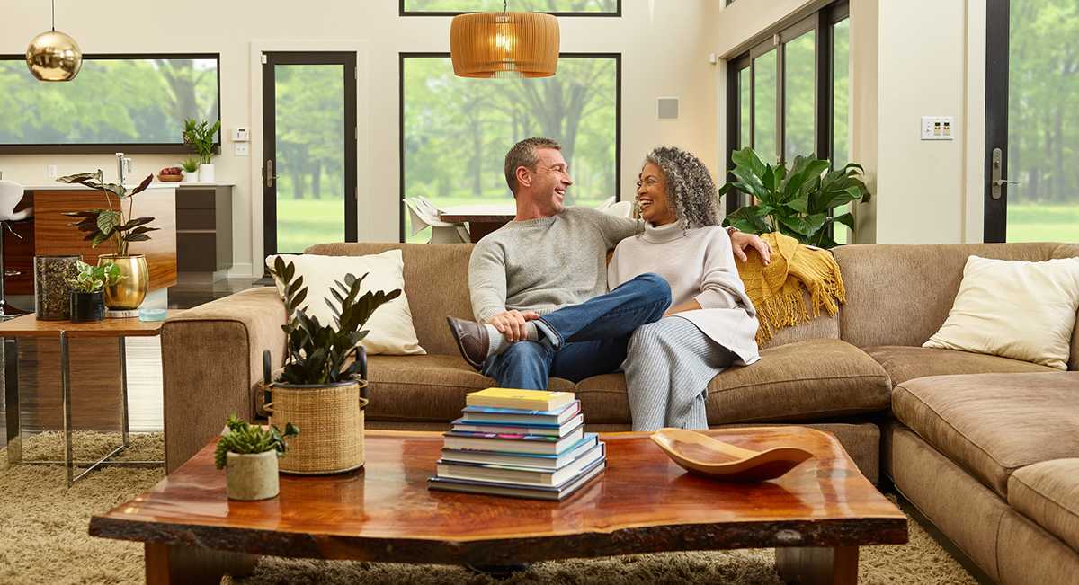 a couple relaxes in living room after having the best home dehumidifier for house installed