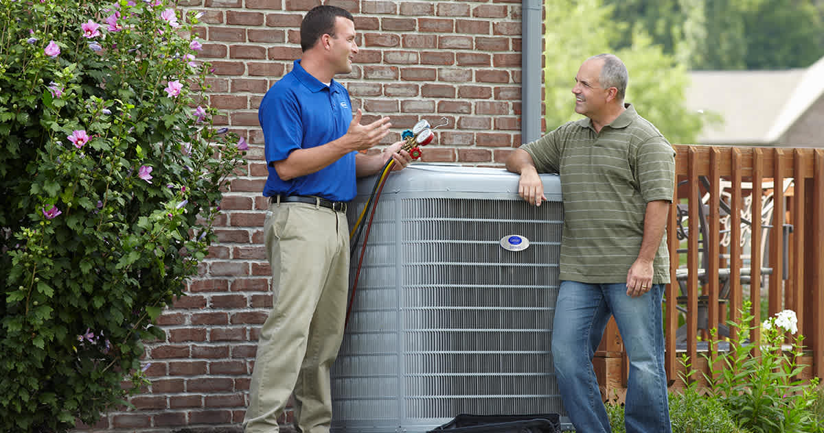 a carrier dealer discusses r22 freon with a homeowner outside a carrier dealer discusses r22 freon with a homeowner outside