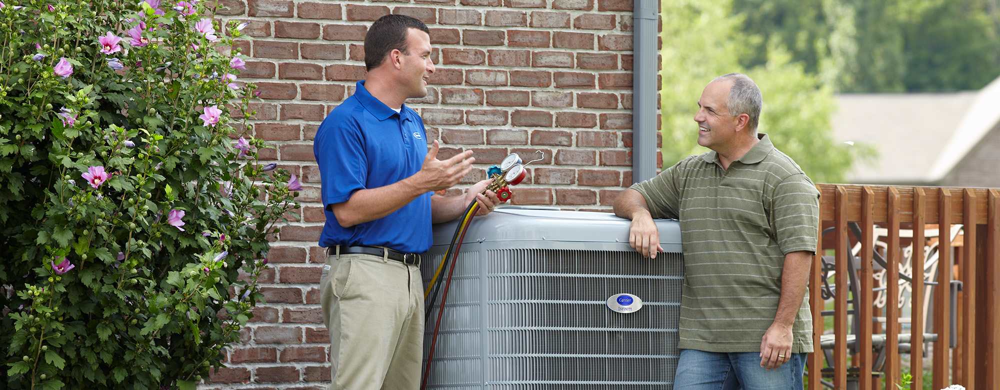 a carrier technician standing by a high efficient heat pump helps a man understand heat pump SEER rating a carrier technician standing by a high efficient heat pump helps a man understand heat pump SEER rating