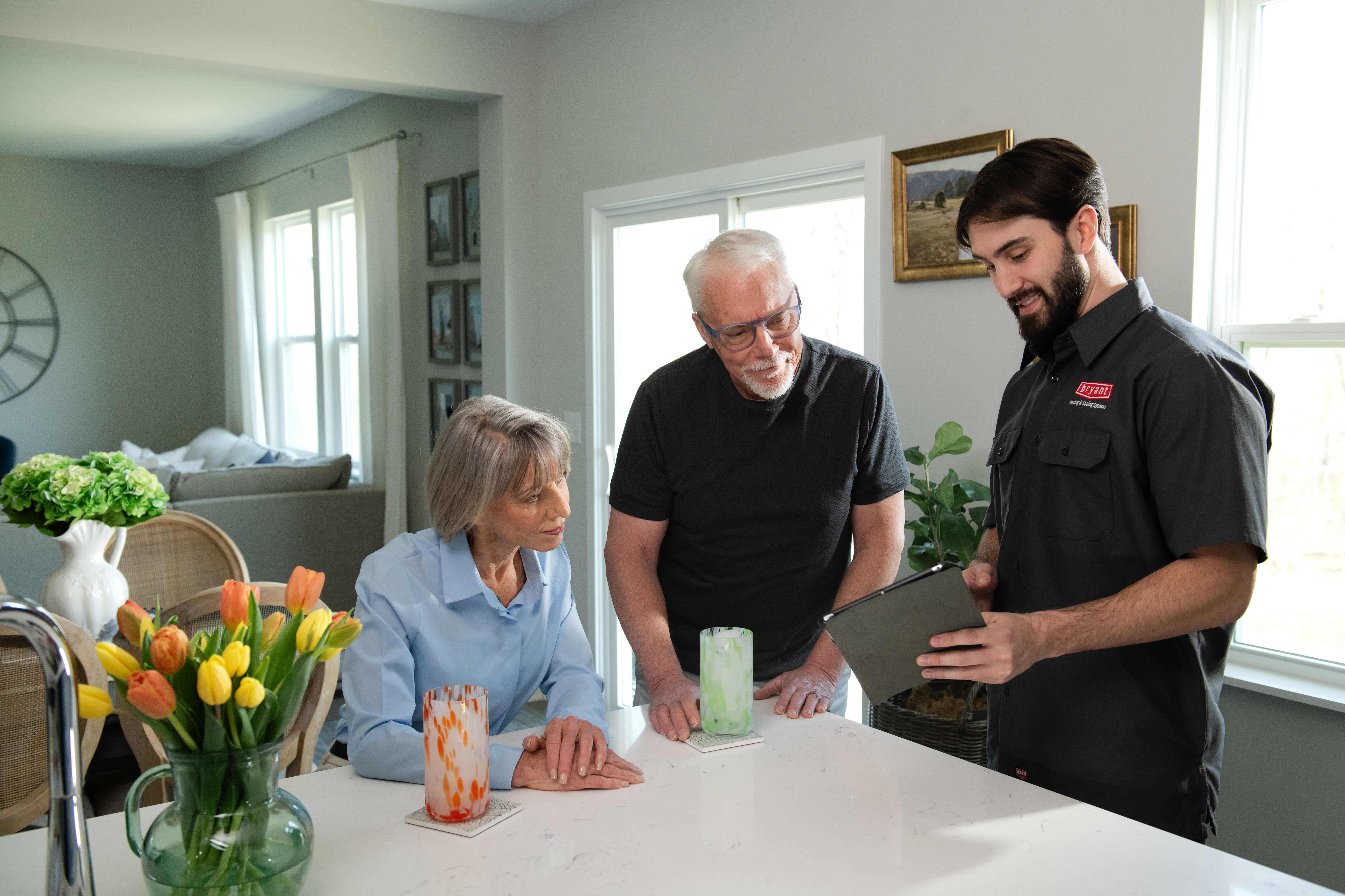 a bryant dealer discusses garage ac units with couple at table a bryant dealer discusses garage ac units with couple at table