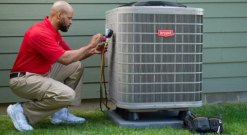 a-bryant-dealer-inspects-heat-pump-system-outside-of-home a-bryant-dealer-inspects-heat-pump-system-outside-of-home