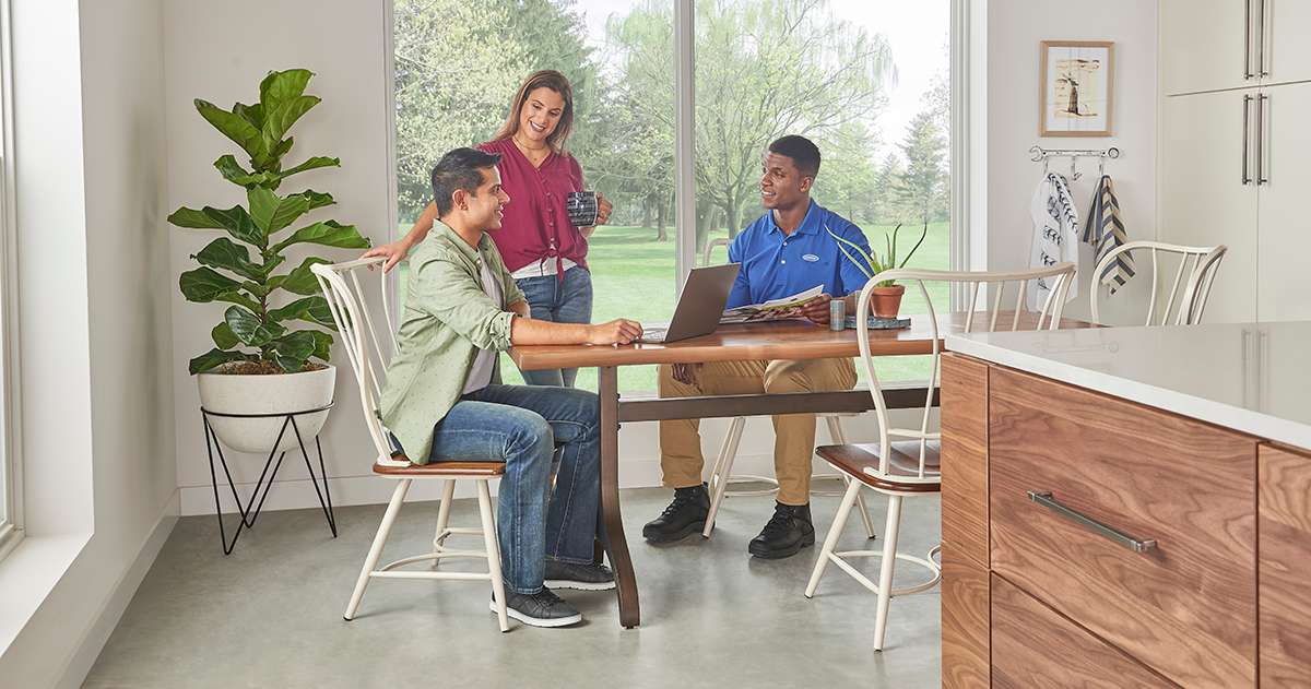a-carrier-dealer-explains-furnace-tax-credit-options-at-kitchen-table-with-homeowners a carrier dealer explains furnace tax credit options at kitchen table with homeowners