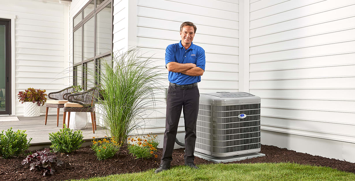 a carrier dealer stands next to 2 ton heat pump a carrier dealer stands next to 2 ton heat pump