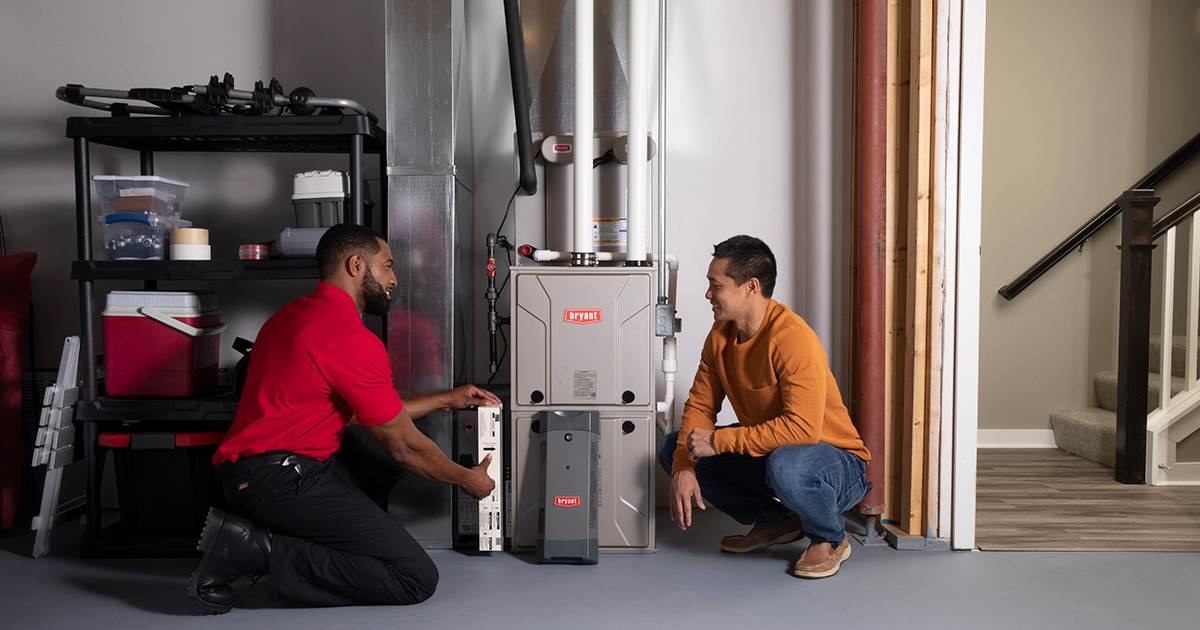a bryant dealer talks to a homeowner during upflow furnace installation