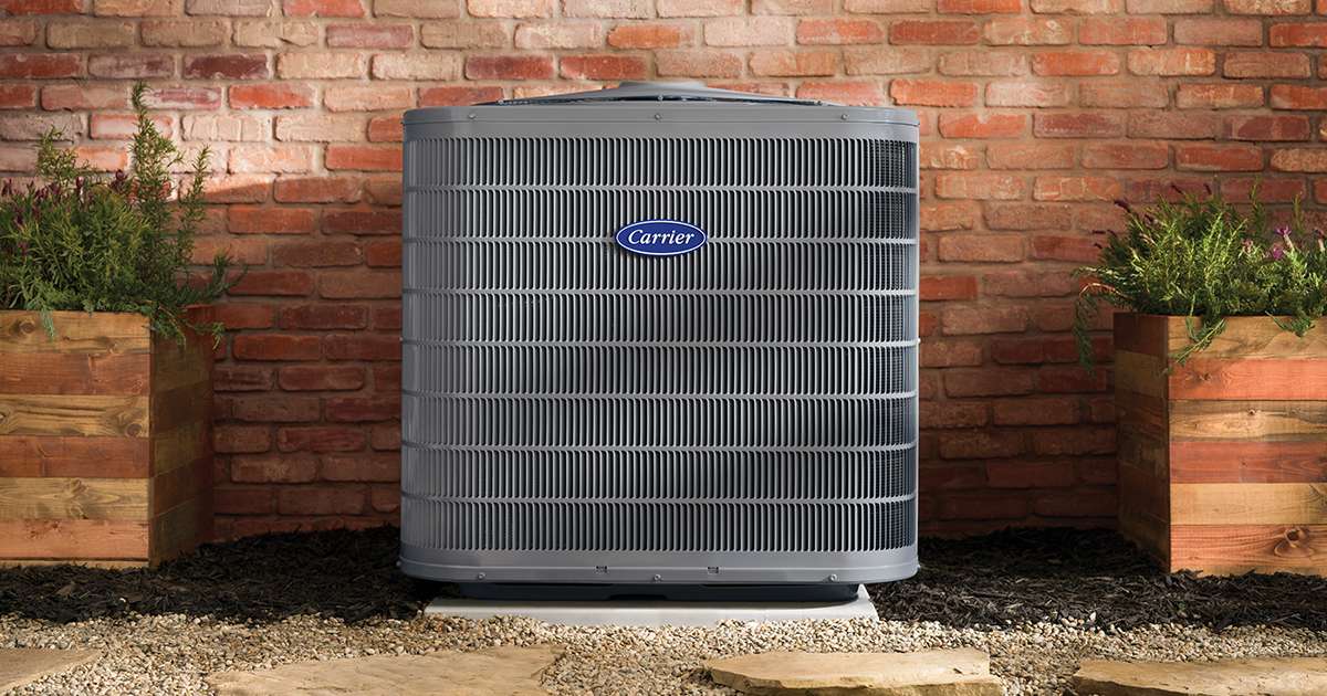 carrier-2-stage-air-conditioner-installed-outside-a-red-brick-home