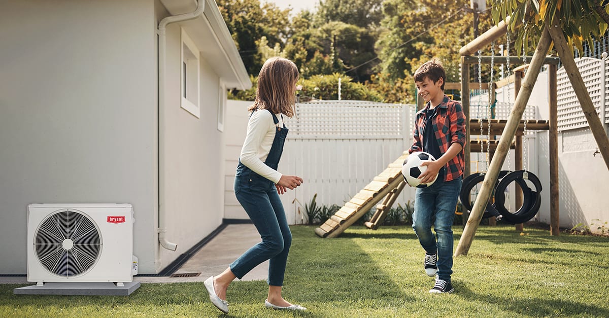 kids play in backyard with best mini split installed nearby