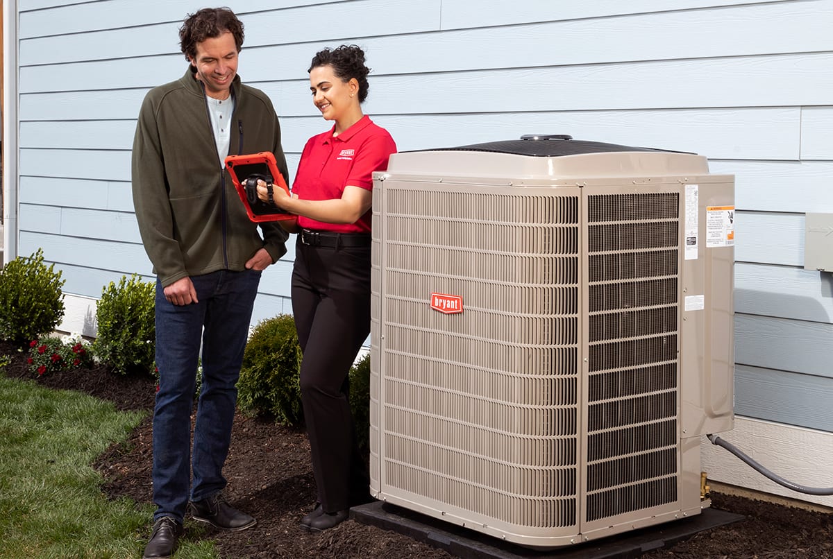 bryant dealer talks to homeowner by energy efficient air conditioner