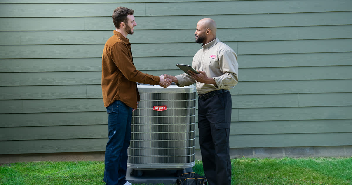 homeowner shakes hands with bryant dealer after variable speed heat pump installation