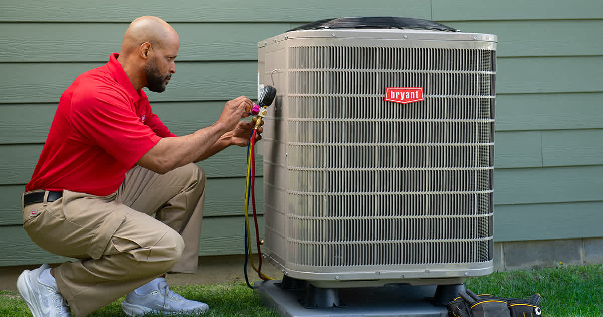 a-bryant-dealer-inspects-heat-pump-system-outside-of-home