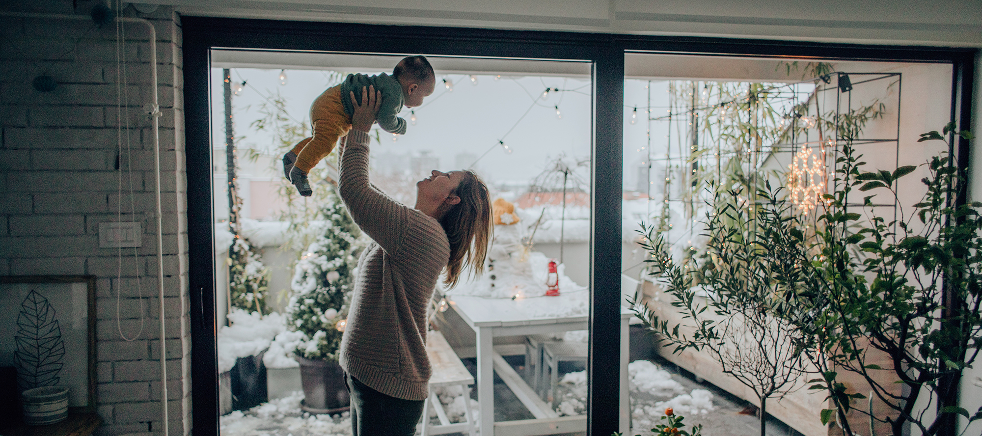 mom-and-baby-in-arms-in-front-of-window mom-and-baby-in-arms-in-front-of-window