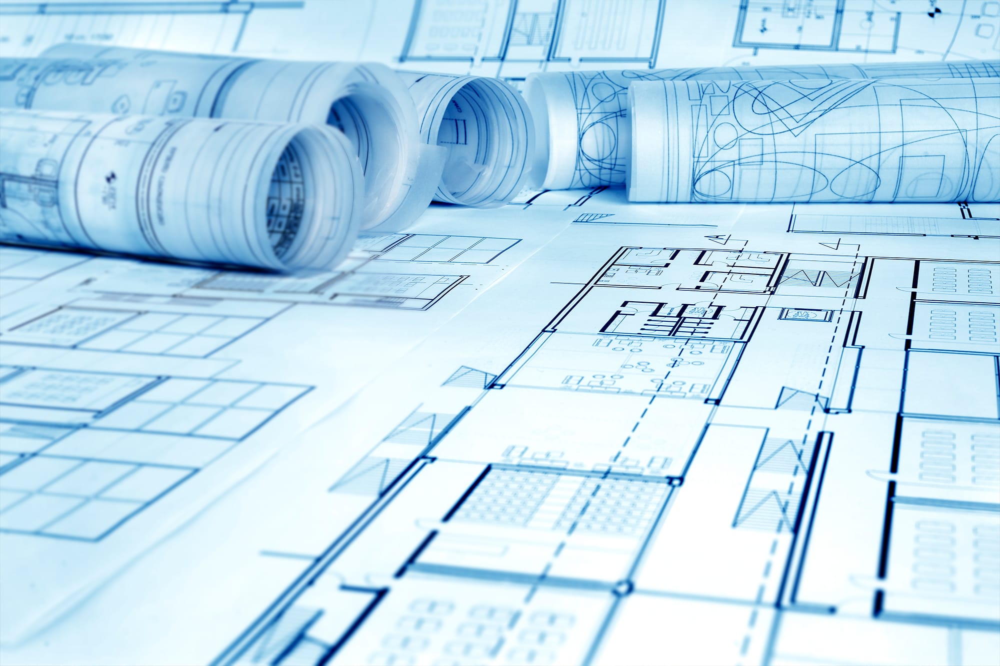 A photo of blueprints rolled on a table A photo of blueprints rolled on a table