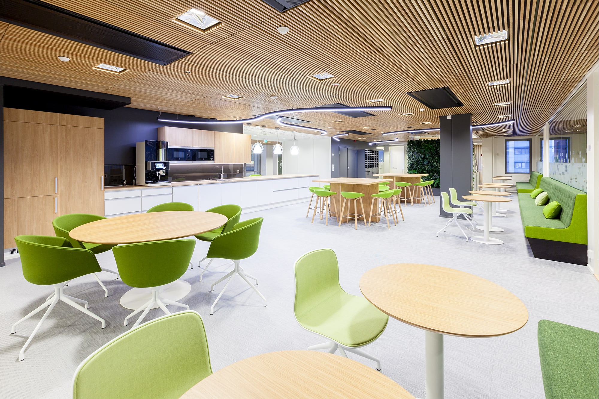 Marioff's main cafeteria with wooden ceiling, tables and light green chairs.