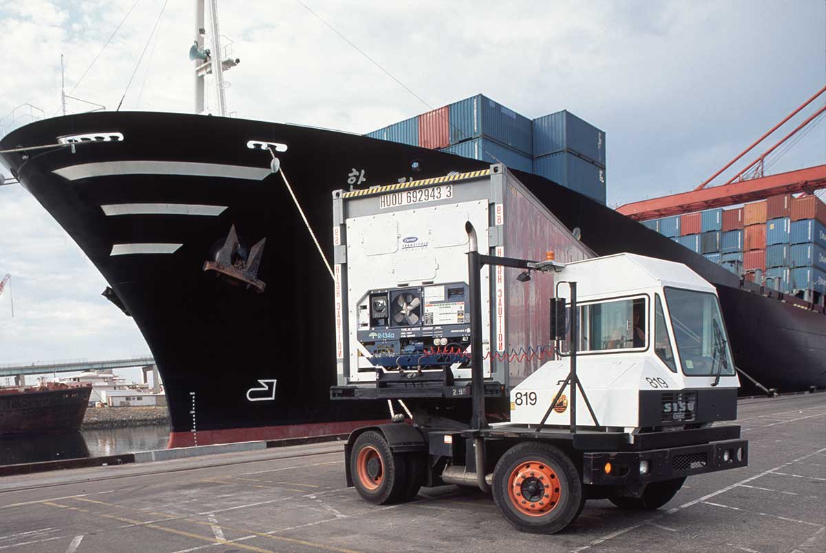 white-truck-loading-container-ship