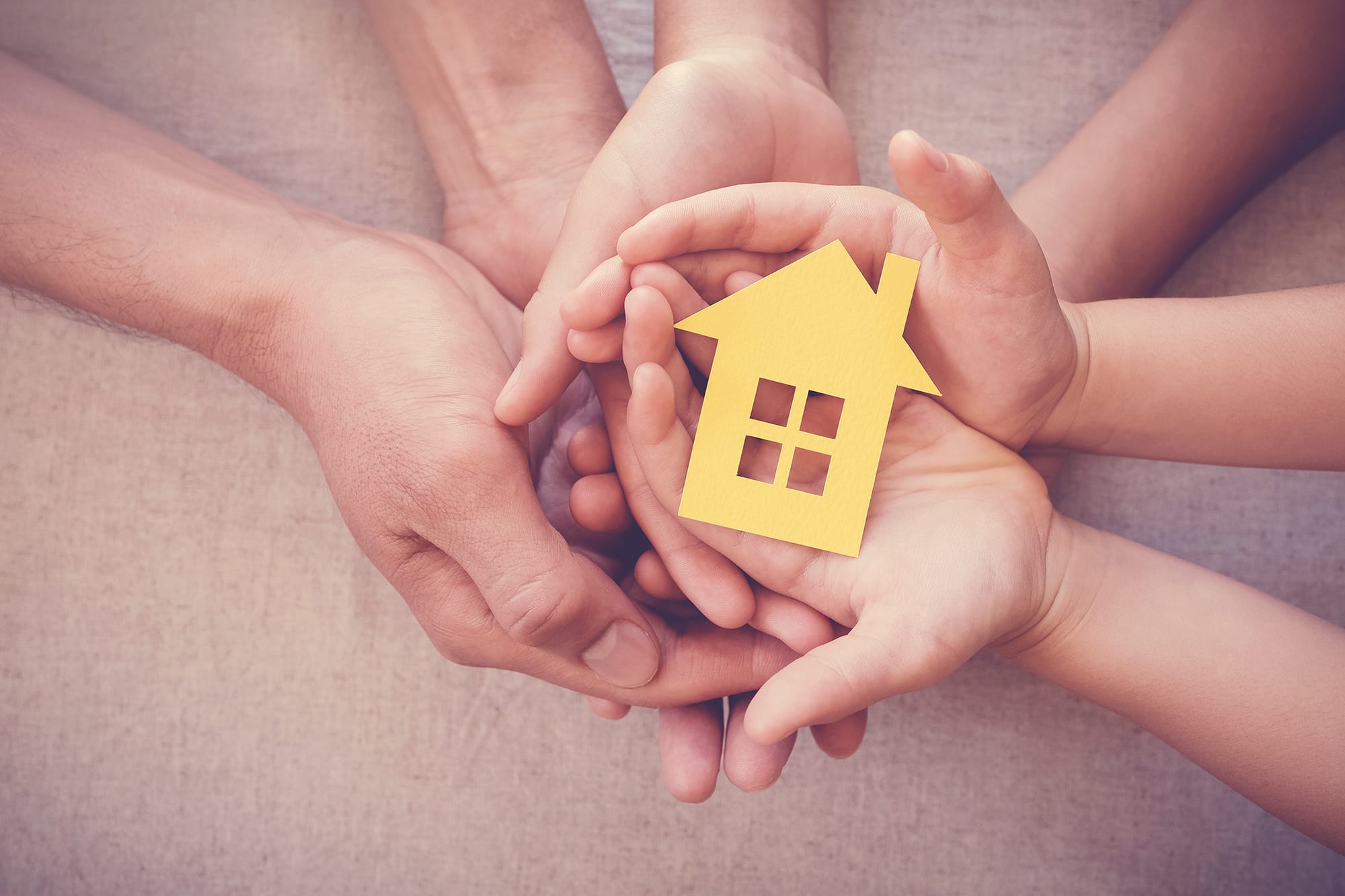 family-holding-house-in-hands