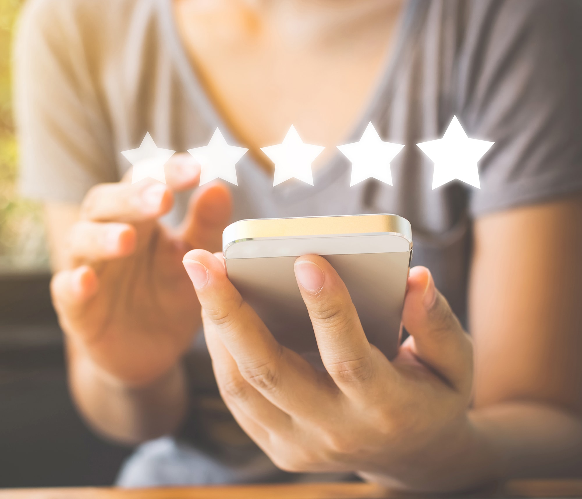 a woman leaves a five-star carrier air conditioner review on her phone