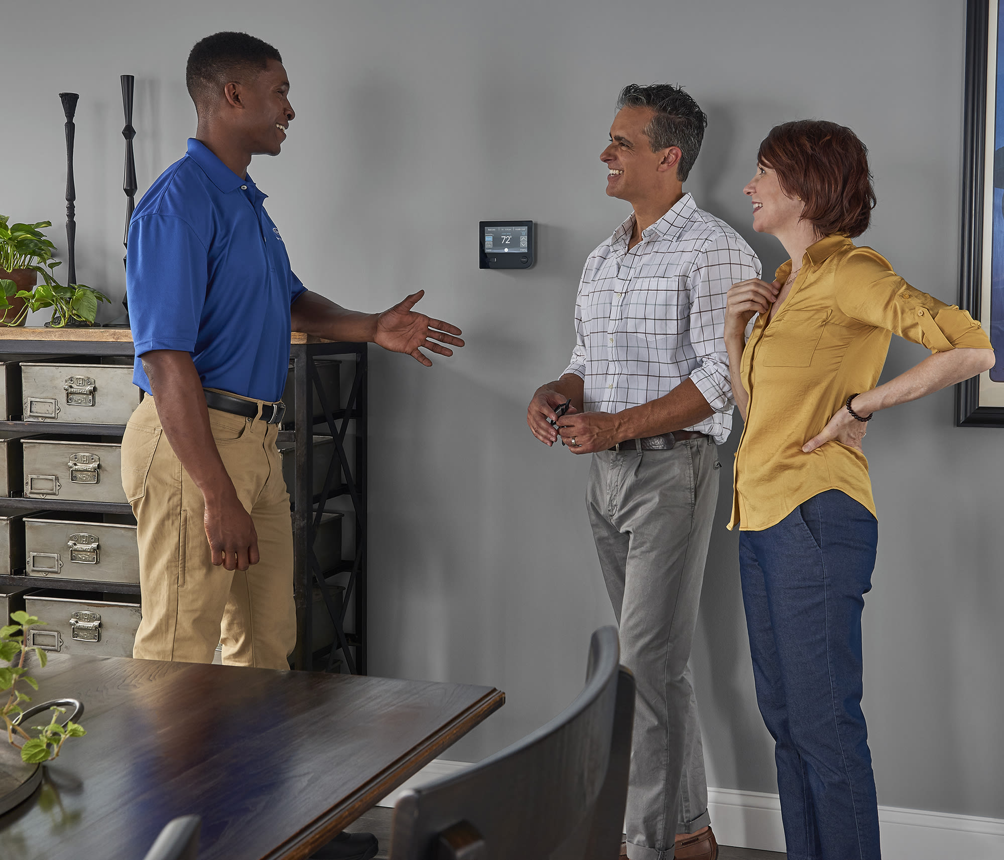 a couple discusses carrier hvac thermostats and the value of a programmable thermostat with a carrier dealer